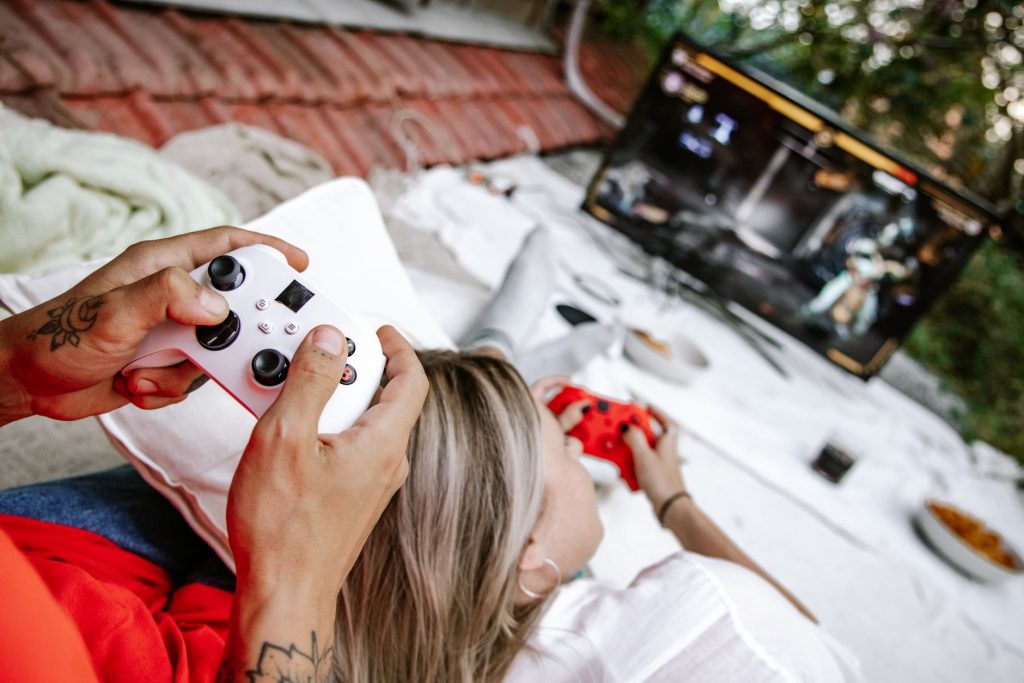 A couple playing video games outdoors, focusing on the controllers and screen. — BLACK168: The Trusted Name for Secure, Enjoy