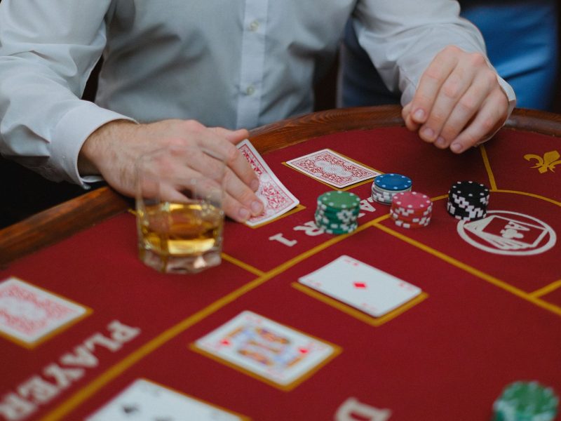 Intense poker game with cards and chips on a red casino table, creating a thrilling atmosphere. — Gain Complete Understanding