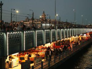 Night view of Galata Bridge bustling with people and distant Galata Tower in Istanbul. — How to Select an Online Soccer Betti