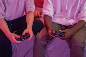 Two friends playing video games together at home, using controllers. — How will you possess a next-level enjoyment at online