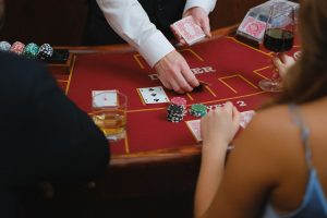 A dynamic scene at a casino card table with players engaged in a game featuring poker chips and drinks. — Mistakes to prevent