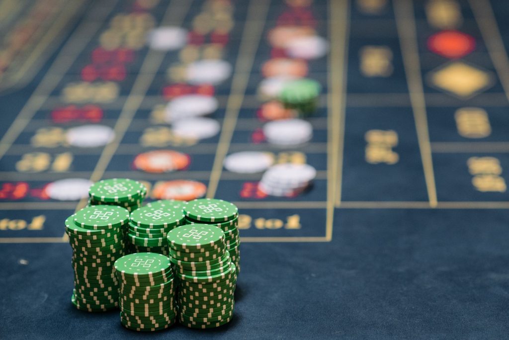 Stack of green poker chips on a casino table, highlighting the gambling theme. — Online betting sites as well as their lucrat
