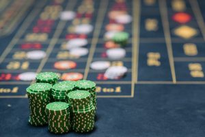 Stack of green poker chips on a casino table, highlighting the gambling theme. — Online betting sites as well as their lucrat