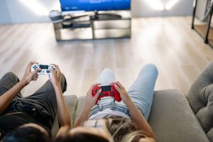Two friends playing video games together indoors with game controllers. — P4xbet Community and Social Features Connecting Cas
