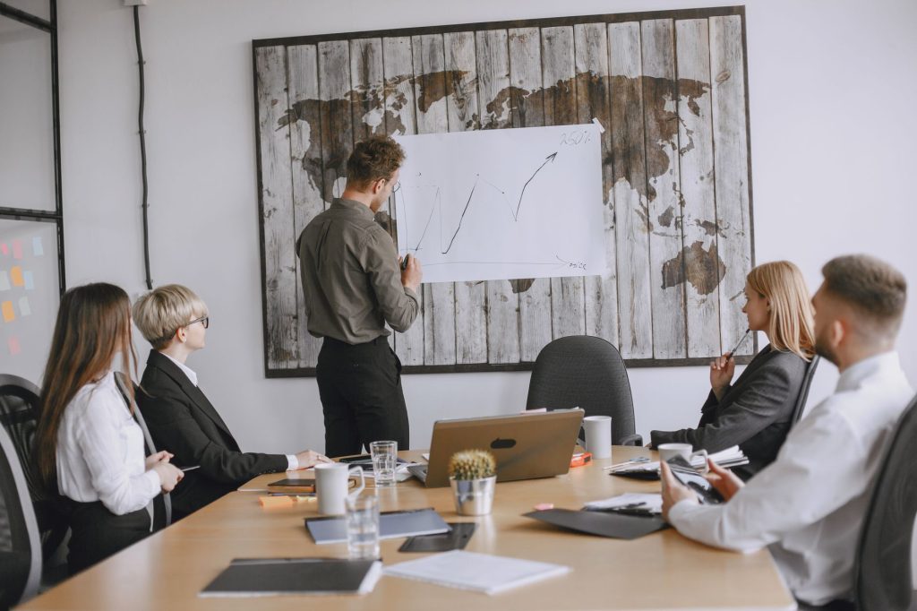 Group of business professionals discussing strategies with growth chart in conference room. — PHFUN: Gaming Excellence from C