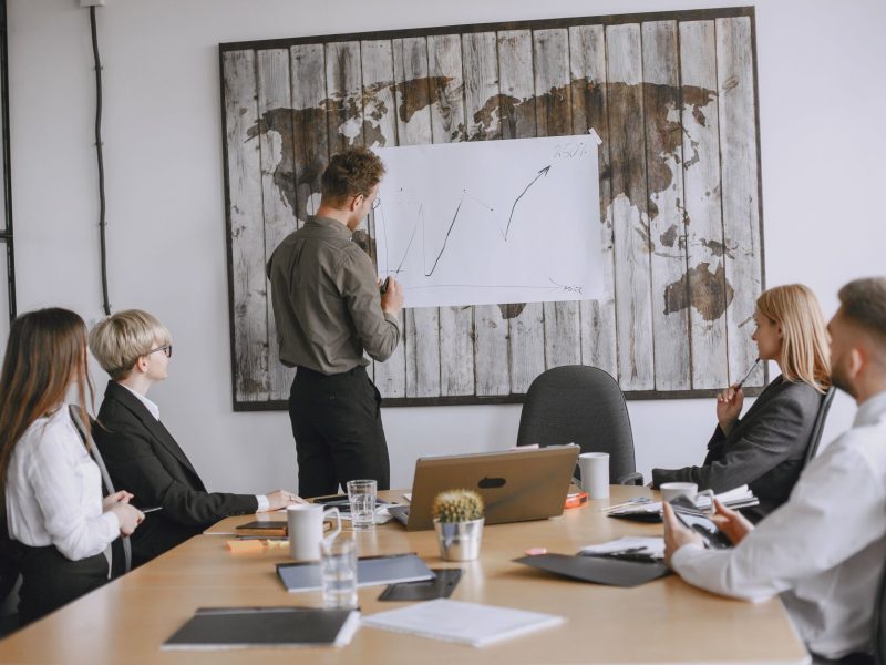 Group of business professionals discussing strategies with growth chart in conference room. — PHFUN: Gaming Excellence from C