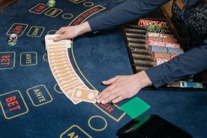 A casino dealer skillfully spreads playing cards on a gaming table, surrounded by colorful poker chips. — Rewards that may be