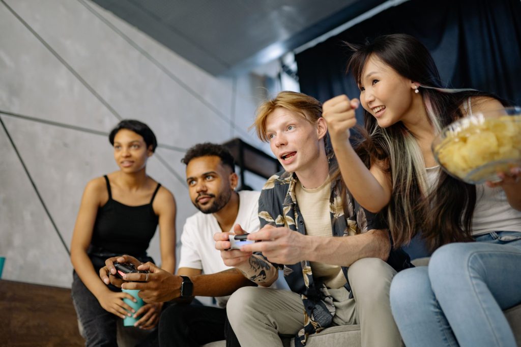 Four friends gaming enthusiastically inside a modern home, enjoying a lively moment. — Staying Ahead of the Competiti