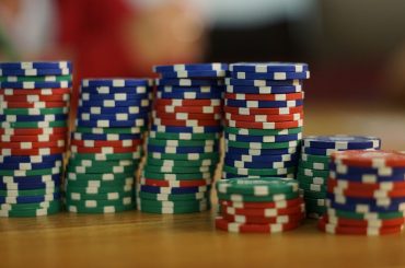 A close-up view of colorful stacked poker chips on a wooden table, perfect for casino themes. — The logic behind trying your