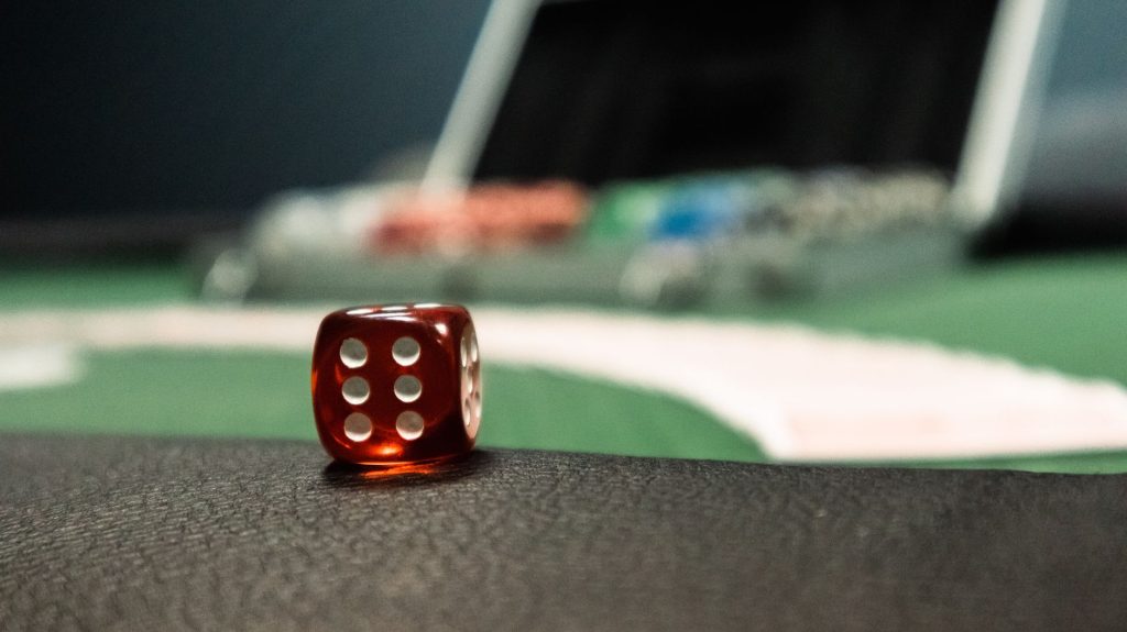 A close-up of a red dice on a casino table, evoking a sense of gambling excitement. — The Wise Wager: Essential Checks to Ver