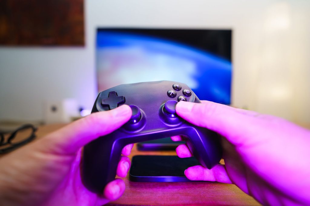 Close-up of hands holding a game controller in front of a TV screen. Perfect for entertainment setups. — Understanding the Ga