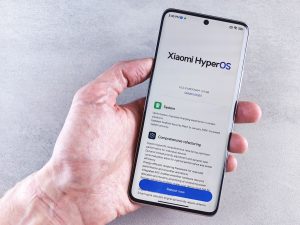 Close-up of a hand holding a Xiaomi smartphone with HyperOS interface, showcasing comprehensive refactoring and system update