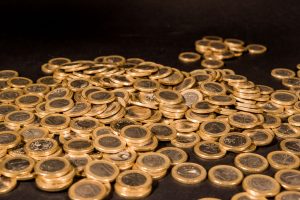 Close-up of a pile of Euro coins scattered on a black surface, representing wealth and finance. — Would you like to create a